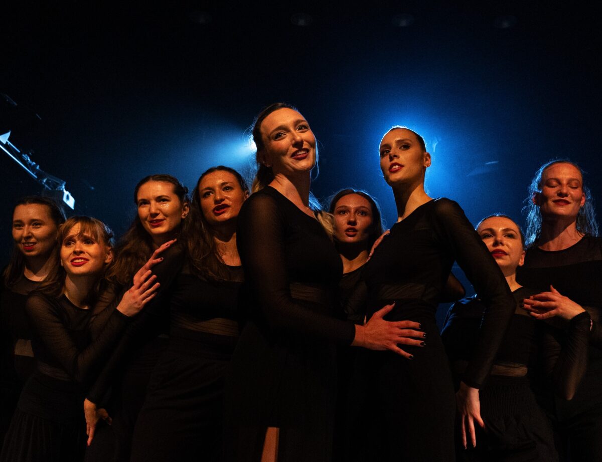 Zdjęcie. Grupa tancerek w scenicznym świetle.