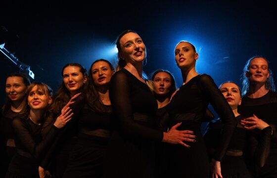 Zdjęcie. Grupa tancerek w scenicznym świetle.