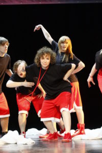 Zdjęcie przedstawia tancerzy na scenie - dziewczyny i chłopców