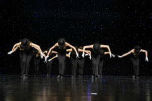 Zdjęcie przedstawia grupę tancerzy na scenie/ Nad nimi wisi napis Ogólnopolskie Spotkania Taneczne Spontan