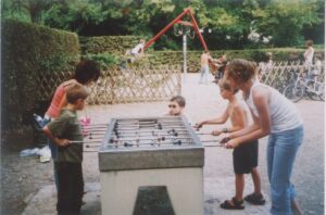 Zdjęcie przedstawia 4 osoby (dorosłych i dzieci) grających w piłkarzyki.