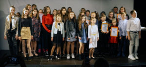 Zdjęcie przedstawia grupę dzieci i młodzieży na scenie