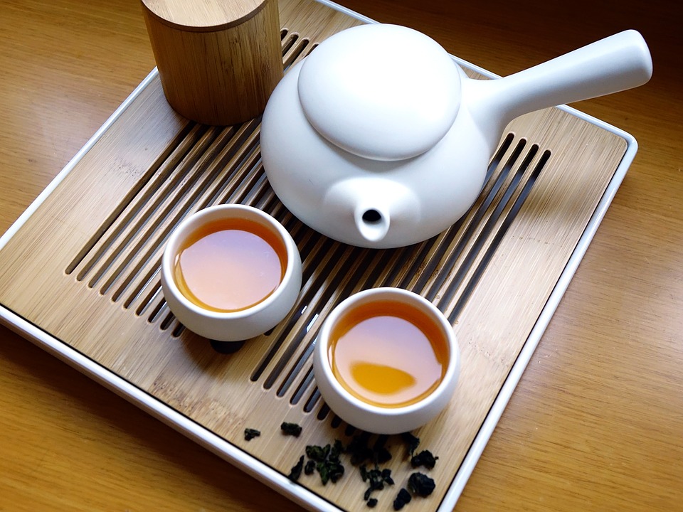 Na zdjęciu widzimy chiński czajniczek do parzenia herbaty oraz dwie filiżanki wypełnione herbatą. Stoją na tacy.