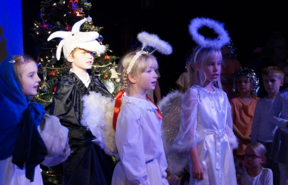 Zdjęcie przedstawia dzieci na scenie ze spektaklu z okazji Świąt Bożego Narodzenia.