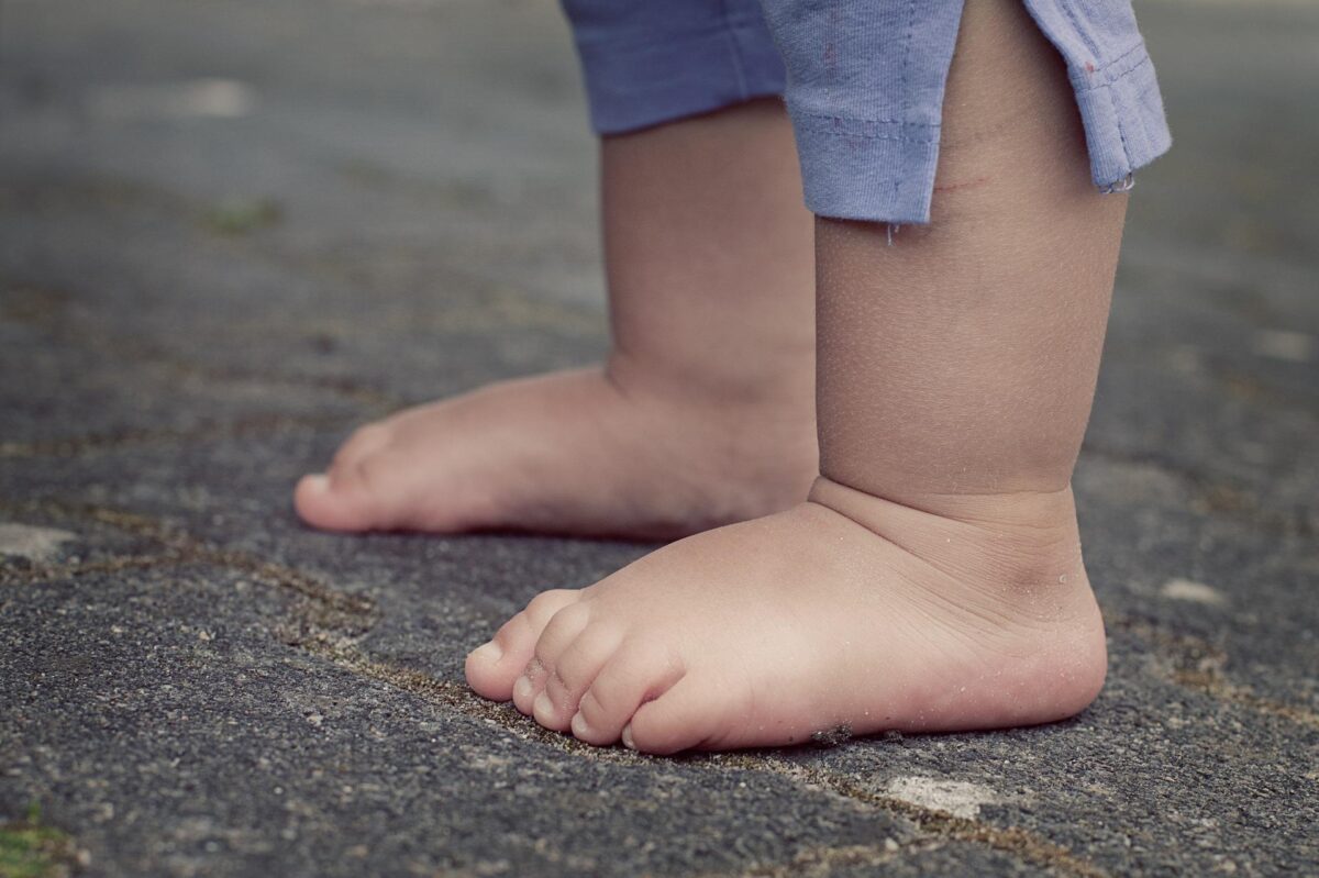 Bose stopy małego dziecka, w spodenkach za kolana