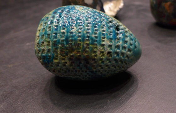 Zdjęcie przedstawia pracę w kształcie dużego, niebieskiego jajka.