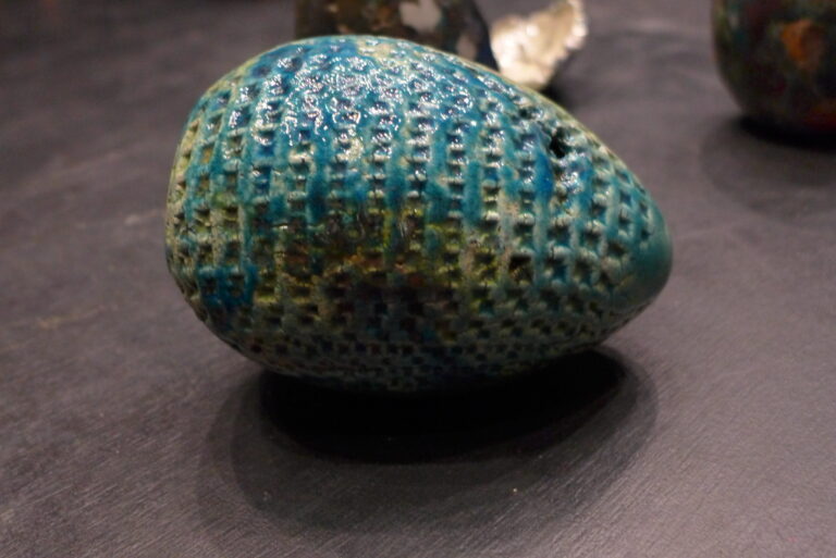 Zdjęcie przedstawia pracę w kształcie dużego, niebieskiego jajka.
