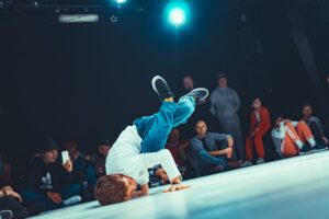 Chłopiec na sc enie tańczy breakdance, za nim widownia