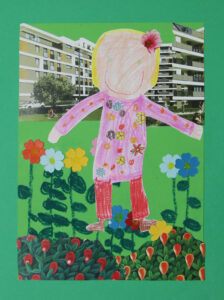 Postać mamy narysowana ręką dziecka, jest wkwiecistej sukience i spodniach, we włosach ma przypięty kwiat, jest w ogródku kwiatowym za nią są bloki