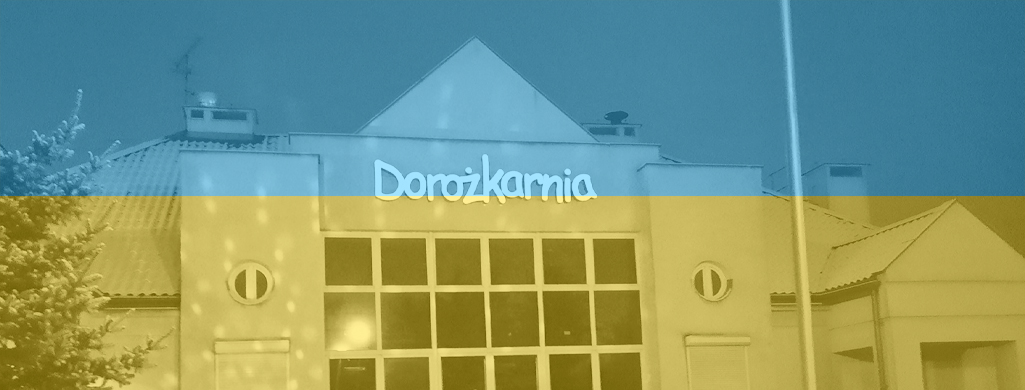 Budynek z napisem - neonem Dorożkarnia, na obrazek nałożony filtr flagi ukraińskiej