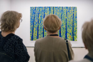 Trzy kobieta patrzą na duży obraz na ścianie