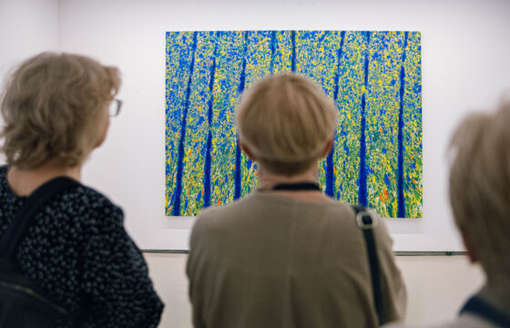 Trzy kobieta patrzą na duży obraz na ścianie