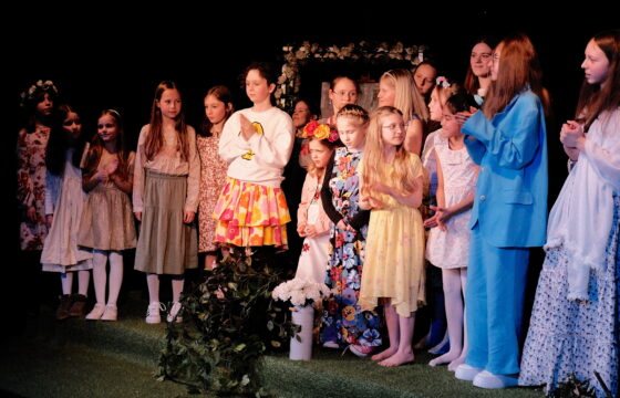 Grupa dzieci i młodzieży - dziewcząt na scenie.