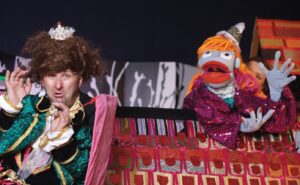 Kukła typu muppet oraz mężczyzna w bajkowym stroju i z koroną na głowie