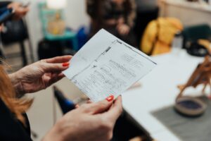 Dłonie tz pomalowanymi paznokciami trzymające kartkę z nutami