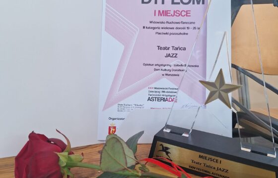 Zdjęcie amatorskie. Widoczny dyplom za zajęcie pierwszego miejsca i kwiat - róża.