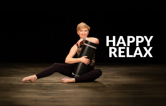 Zdjęcie kobiety z matą do ćwiczeń jogi. Napis |"Happy Relax"
