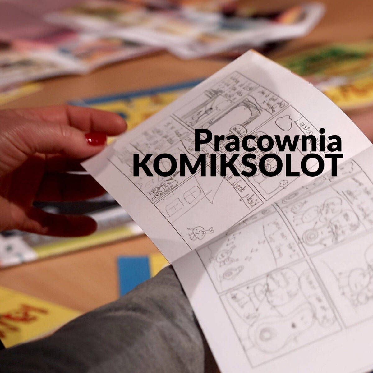 Zdjęcie dłoni trzymających szkicownik z komiksem. Napis "Pracownia Komiksolot"
