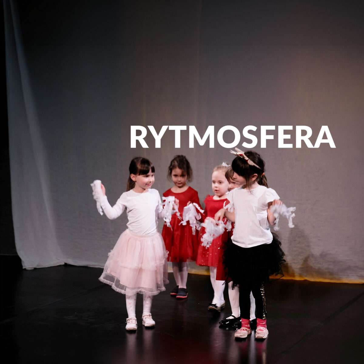 Zdjęcie grupki dziewczynek na scenie. Napis "Rytmosfera"