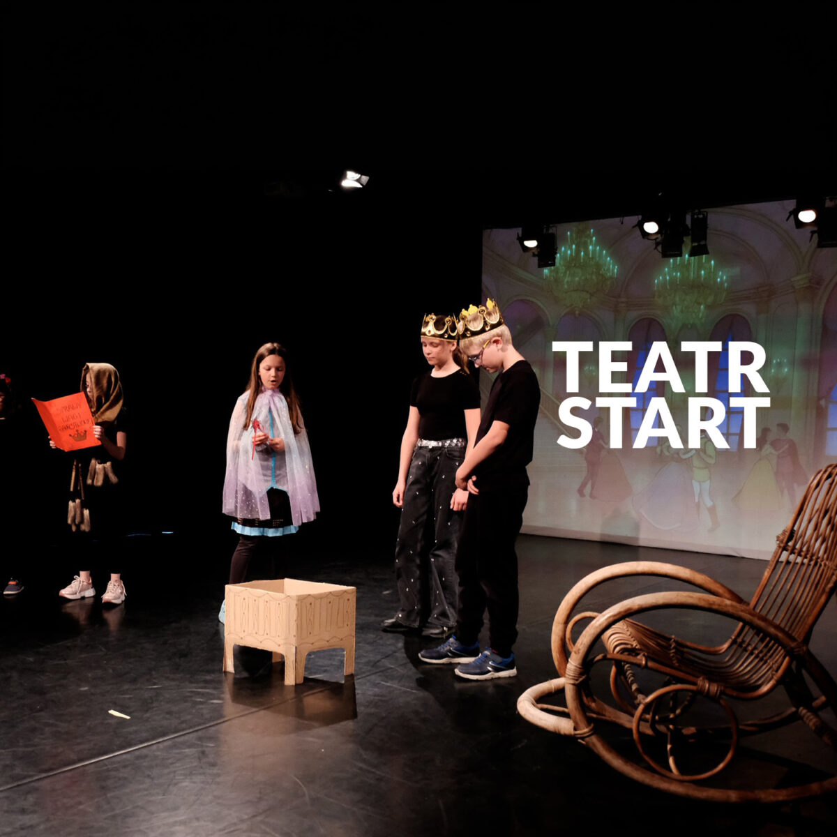 Zdjęcie grupy dzieci odgrywających scenkę. Napis "Teatr START"